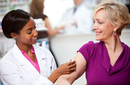 Smiling Price Rite medical professional giving customer a COVID Vaccine